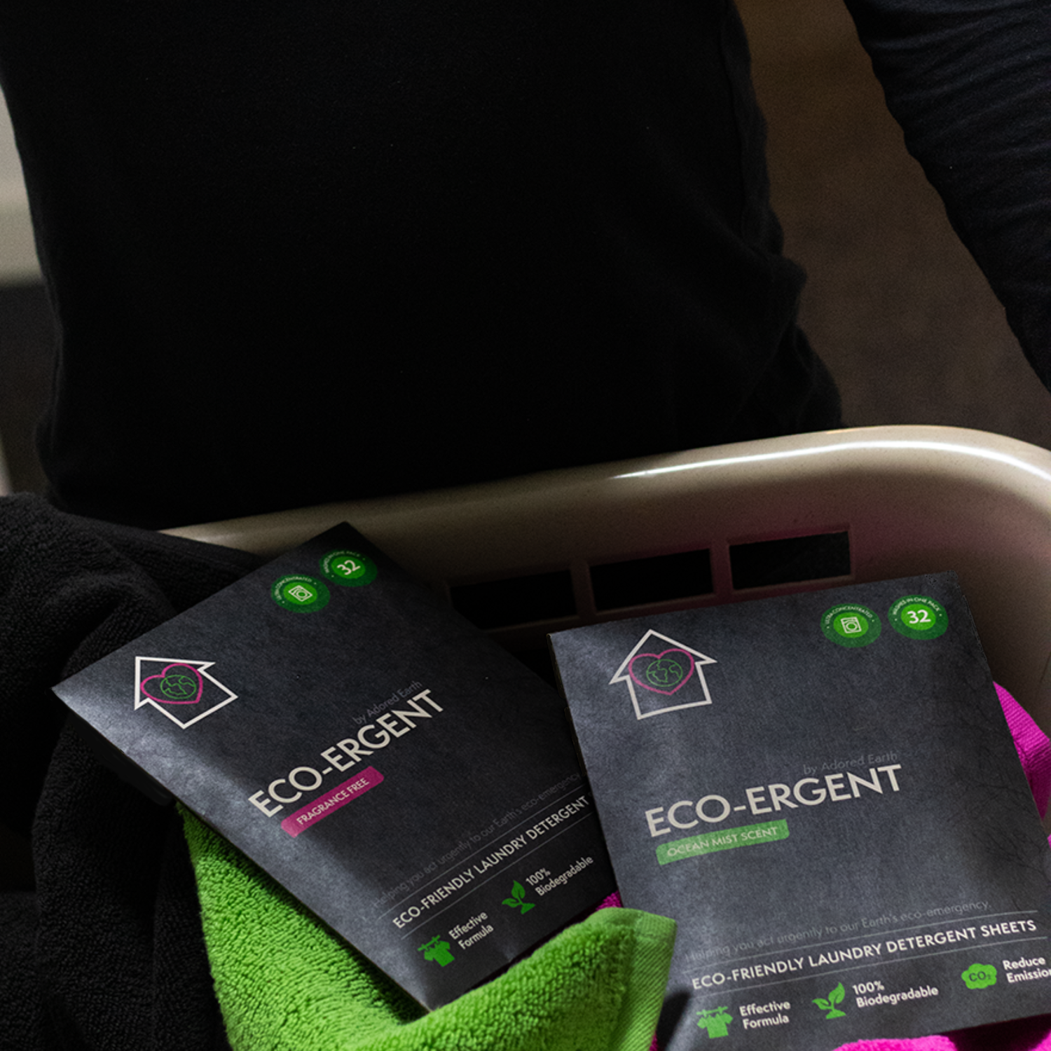 Adored Earth Eco-Ergent Laundry Detergent Sheets being carried in a washing basket containing brand coloured towels.